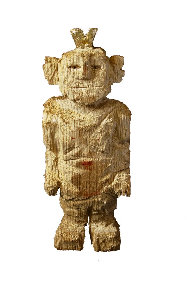 Eine grob behauene Holzskulptur eines Menschen mit einer kleinen goldenen Krone auf dem Kopf – Symbol für Orientierung und Zuversicht nach einem Verlust